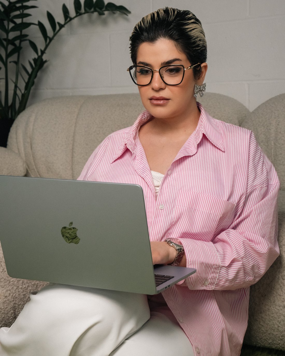 Fatima answering client messages on her laptop
